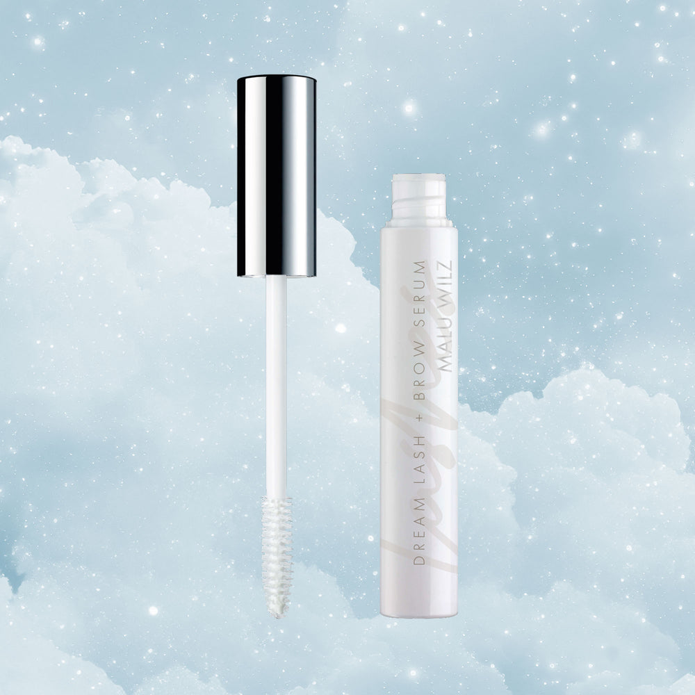 Malu Wilz Dream Lash + Brow Serum vor einem Hintergrund aus Wolken und funkelnden Sternen.