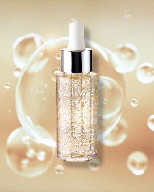 Malu Wilz Caviar Gold Luxury Concentrate in einem Glasflakon mit Pipette vor einem Hintergrund aus goldenen Blasen.