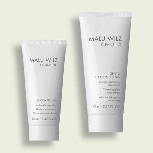Zwei weiße Tuben aus der Malu Wilz Reinigungsserie: 'Jojoba Peeling' und 'Gentle Cleansing Foam'.